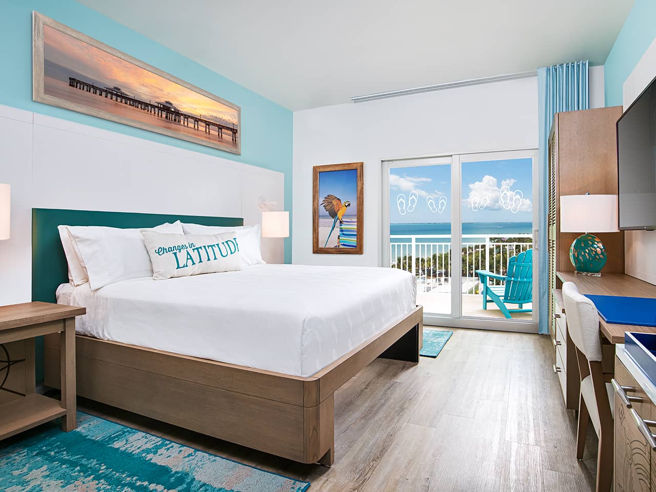 Two blue beach chairs overlooking a pool with Jimmy Buffett themed glasses on a side table